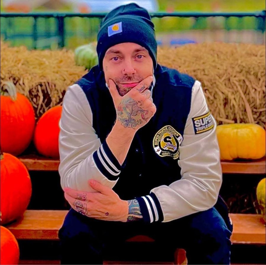 Danny Thomas in a beanie and varsity jacket at a pumpkin patch